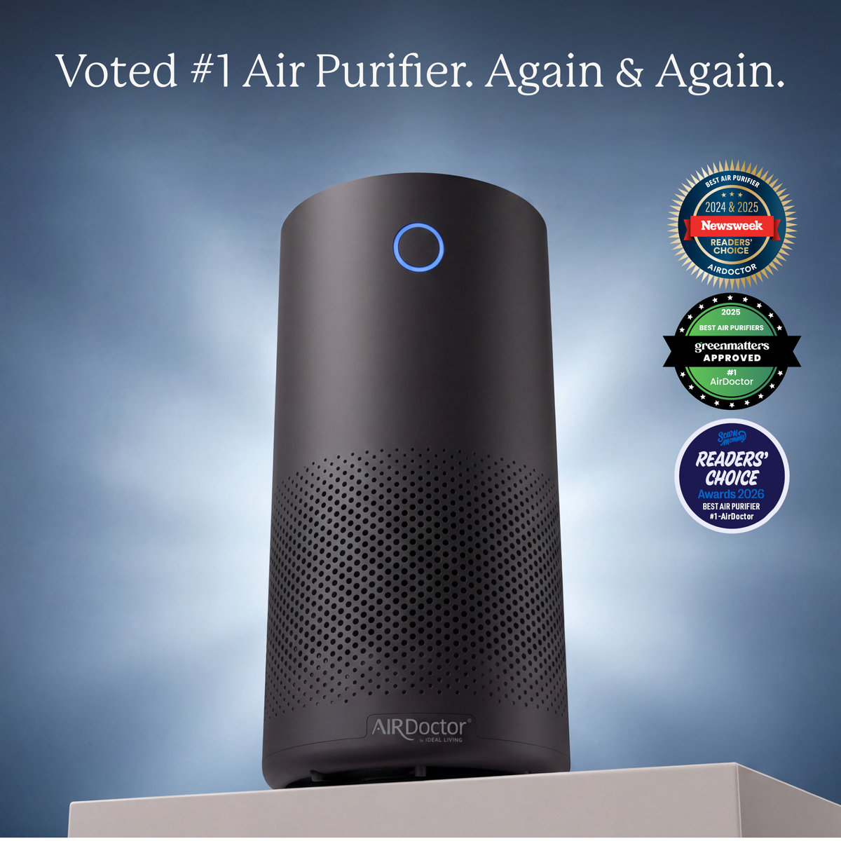 A black cylindrical AIRDoctor air purifier with a blue indicator light, shown on a pedestal against a blue gradient background with promotional text and award badges on the right.