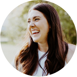 Woman with long brown hair smiling outdoors